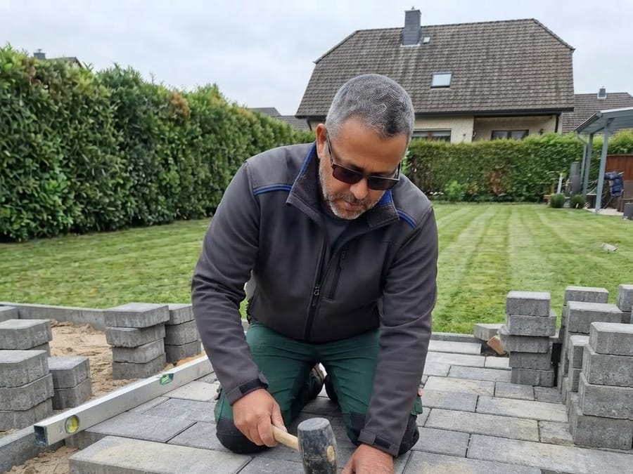 Verlegen von Pflastersteinen für eine neue Terrasse
